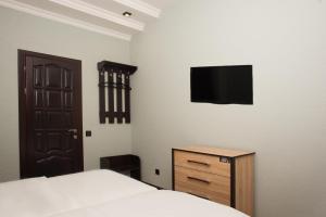 a bedroom with a bed and a tv on the wall at Sova in Odesa