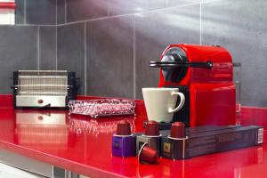 Una cafetera roja en una barra roja con una taza en My Penthouse Valencia, en Valencia