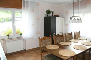 a dining room with a table and chairs and a refrigerator at Ferienhaus im Nürburgring in Herschbroich +33 photos