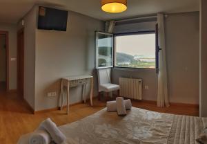 1 dormitorio con cama, escritorio y ventana en As Eiras Lires Hotel Restaurante, en Lires