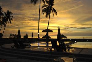 zachód słońca na plaży z leżakami i parasolami w obiekcie Lagoon beach resort w mieście Gitagun