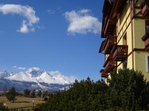 a building with a view of a snow covered mountain at Sunny apartmány Veľká Lomnica in Veľká Lomnica