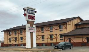 a car parked in front of a hotel room at Homestead Inn in Wolf Point