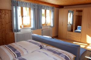 a bedroom with a bed and two windows at Ferienwohnung Hausladen in Arnbruck