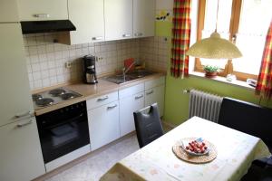 a kitchen with a table with a bowl of fruit on it at Ferienwohnung Hausladen in Arnbruck