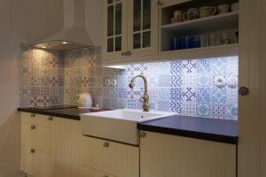 a kitchen with a sink and blue and white tiles at Krk Houses in Kornić +85 photos