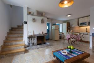a kitchen and a living room with a fireplace and a table at Krk Houses in Kornić