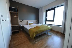 a bedroom with a bed and a large window at Tananger Apartment Hotel in Tananger