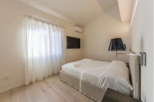 切爾沃港的住宿－Appartamento Il Principe，白色的卧室设有床和窗户