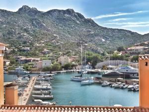 a group of boats docked in a harbor with mountains at Appartamento Il Principe in Porto Cervo