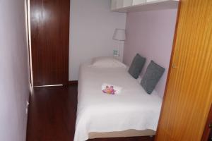 フンシャルにあるCasa Violetaのベッドルーム1室(花の飾られた白いベッド1台付)