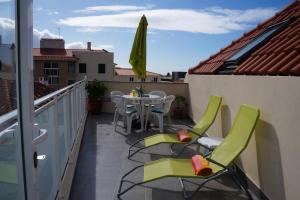 een patio met een tafel en stoelen op een balkon bij Casa Violeta in Funchal