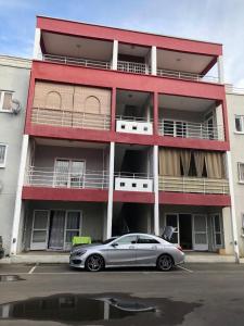 a silver car parked in front of a red building at Kays Residence in Pereybere