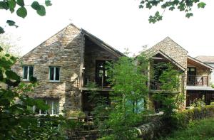 an old stone house with a balcony and trees at Alston Art Apartments in Alston