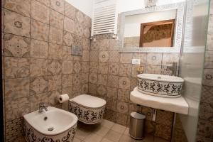 a bathroom with a sink and a toilet and a mirror at Luxury Relais Cuore Sabino in Stimigliano