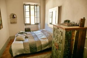a bedroom with a bed and a wooden dresser at El Asiento Del Azar in Banyeres del Penedes