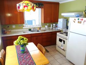 a kitchen with a table and a white refrigerator at 2 bedroom Wiffen Cottage in Port Albert