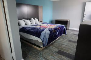 a bedroom with a bed with a blue comforter at Thunderbird Motel in Bishop
