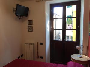 a room with a door and a tv and a window at La Posada in Corniglia