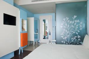 a living room with blue walls and a tv at JR Hotels Bari Grande Albergo delle Nazioni in Bari