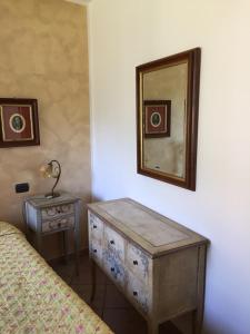 a bedroom with a dresser and a mirror on the wall at La Posada in Corniglia
