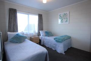 Rose Apartments Central Rotorua- Accommodation & Private Spa tesisinde bir odada yatak veya yataklar