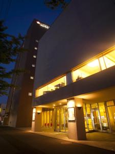 a large building with lights on at night at Apple Palace Aomori in Aomori