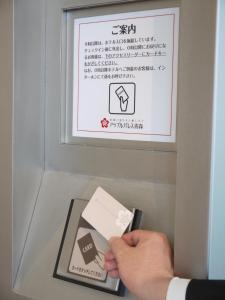 una persona sosteniendo un trozo de papel en una máquina atmosférica en Apple Palace Aomori, en Aomori