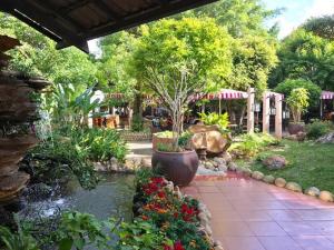 a garden with a pond with flowers and a tree at Nhà Khách T284 in Buon Ma Thuot +27 photos