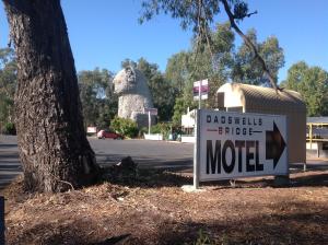a sign in front of a building next to a tree at Grampians Motel /Hotel in Dadswells Bridge