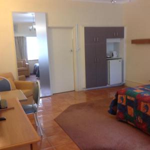 a living room with a couch and a kitchen at Grampians Motel /Hotel in Dadswells Bridge