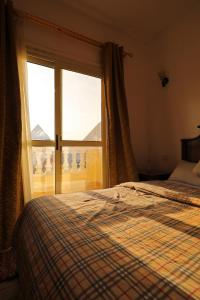 a bedroom with a bed and a large window at Pyramids Loft Guesthouse in Cairo