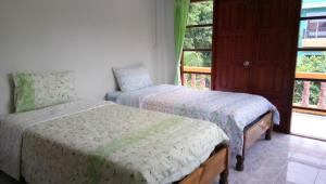 1 dormitorio con 2 camas y ventana en Samui Poshtel, en Chaweng