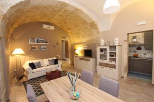 a living room with a table and a couch and a kitchen at Casa Gargallo 28 in Siracusa