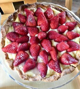 a pie with strawberries on top on a glass plate at La Goiaba B&B in Senigallia +53 photos