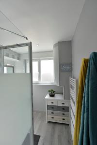 a bathroom with a dresser and a mirror at Opal'évasion - RDC- Cocon pour 2 pers - 250m de la mer in Berck-sur-Mer