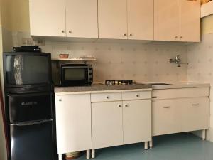 kuchnia z czarną lodówką i kuchenką mikrofalową w obiekcie Flat Low cost w mieście Sperlonga
