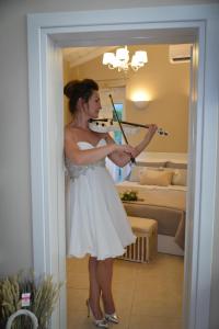a woman in a white dress playing a violin at Meni Sweet Luxury Home in Volos