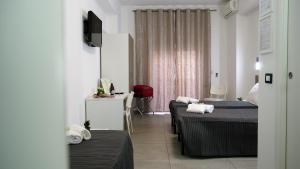 Pokój hotelowy z 2 łóżkami i biurkiem w obiekcie Tiburtina Royal Suites w Rzymie