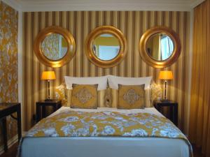 a bedroom with a bed with three mirrors on the wall at Boutique Hotel Sir & Lady Astor - The Charming City Hotels in Düsseldorf
