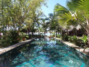 una piscina en un complejo con palmeras en Full Moon Beach Resort en Mui Ne