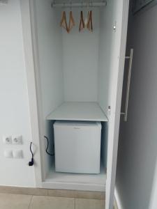 um closet com um pequeno frigorífico branco em Hostal Brisas de Conil em Conil de la Frontera