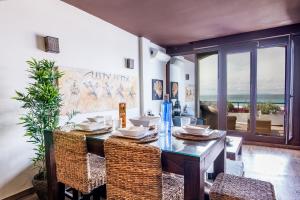 a dining room with a table and chairs and a window at Lances Beach Penthouses in Tarifa +30 photos