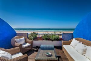 eine Terrasse mit Stühlen, einem Tisch und Strand in der Unterkunft Lances Beach Penthouses in Tarifa