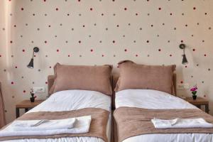 two beds in a bedroom with red dots on the wall at Boulevard Prishtina in Pristina