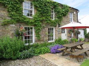 a table and umbrella in front of a building at Eastview Bed and Breakfast in Garrigill