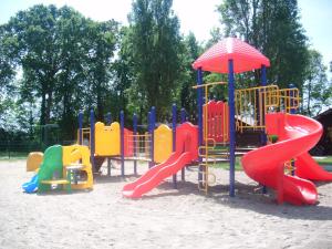 a playground with colorful play equipment in the sand at camping Le Kermadec in Ambon