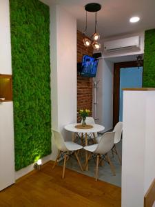 a green wall in a dining room with a table and chairs at Apartament Starowiślna in Krakow