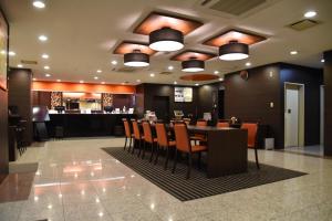 a restaurant with a table and chairs and a bar at APA Hotel Isesaki-Eki Minami in Isesaki