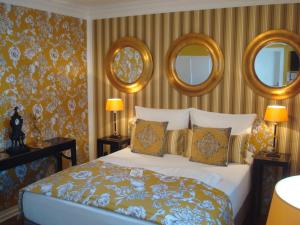 a bedroom with a bed with three mirrors on the wall at Boutique Hotel Sir & Lady Astor - The Charming City Hotels in Düsseldorf